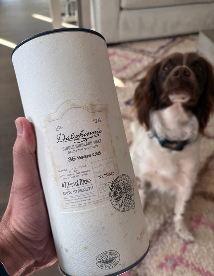 Gregor Cattanach holding a rare Dalwhinnie 36 Year Old whisky with his dog Brodie