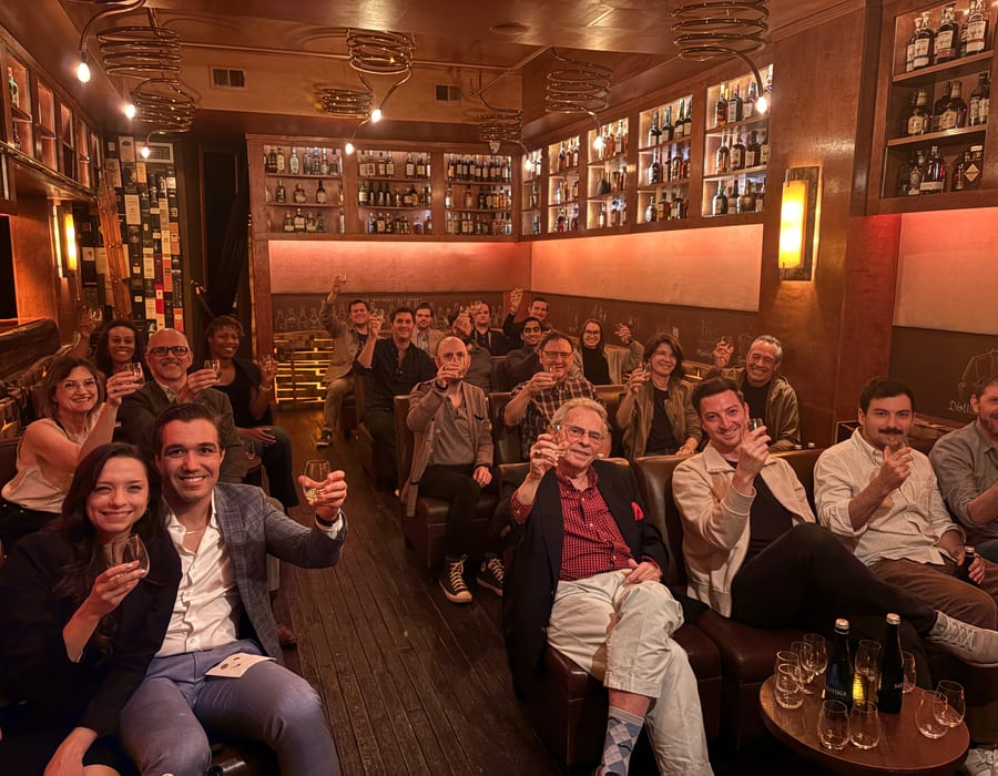 Whisky tasting event with guests raising glasses